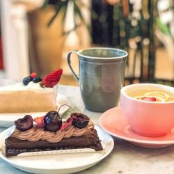 Many hands grabbing cakes from a plate