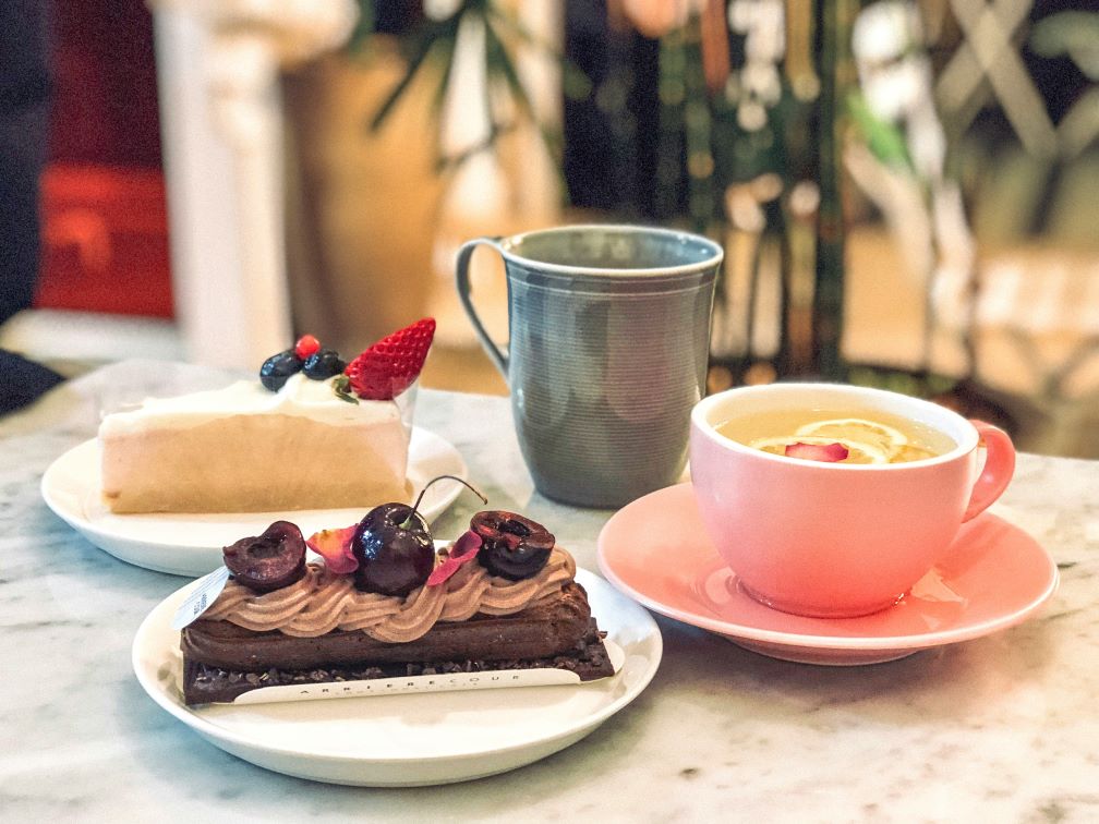 A variety of cakes and cups of tea on a table
