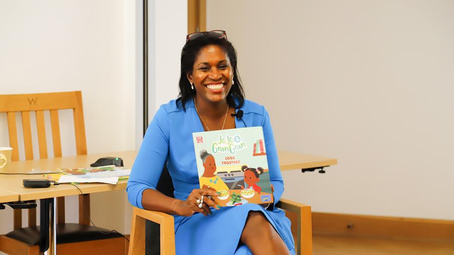 Laura Henry-Allain holding up the book JoJo & Gran Cook Together